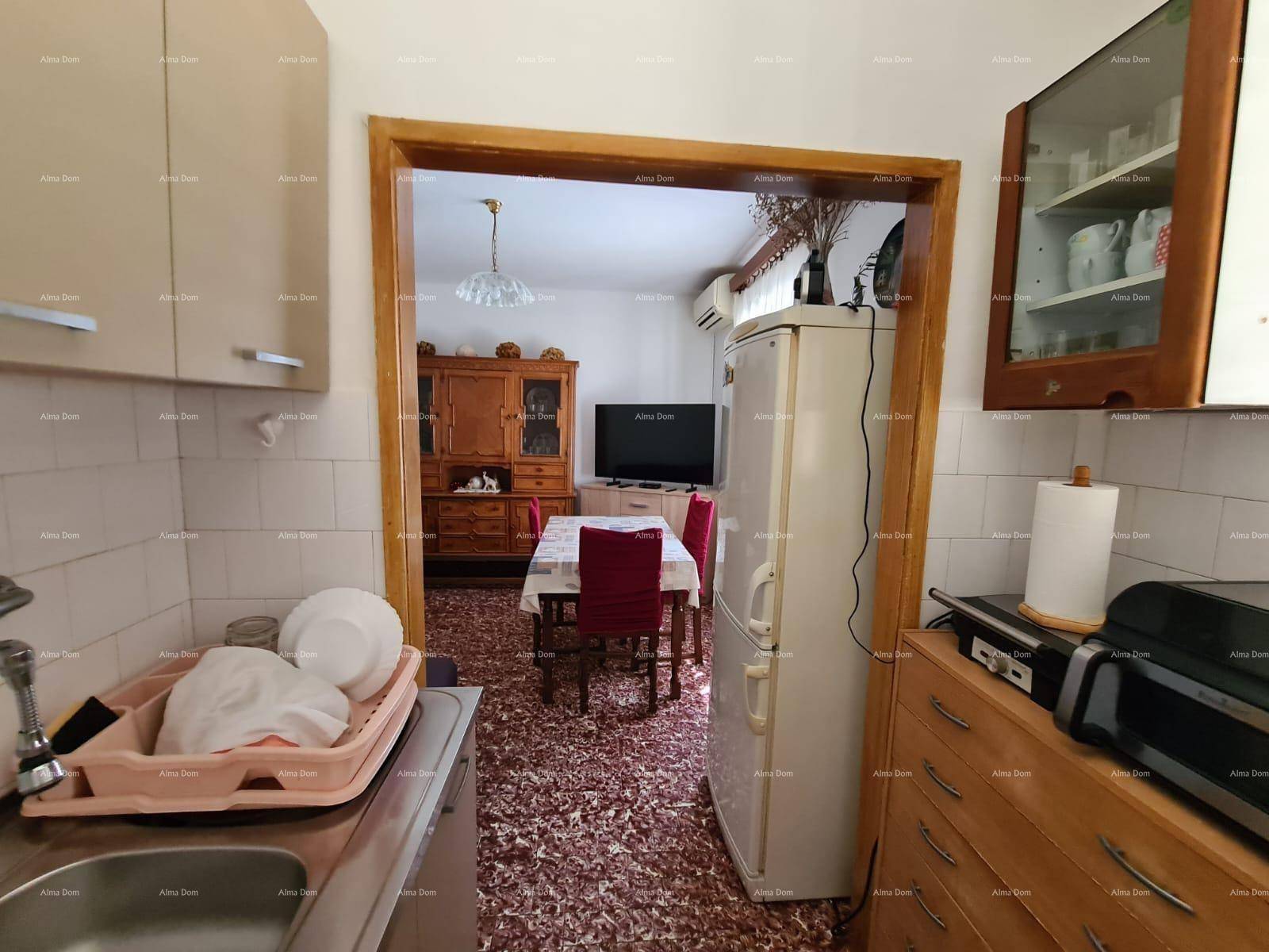 Küche mit Blick in den angrenzenden Wohn-Essbereich, ausgestattet mit Kühlschrank.
