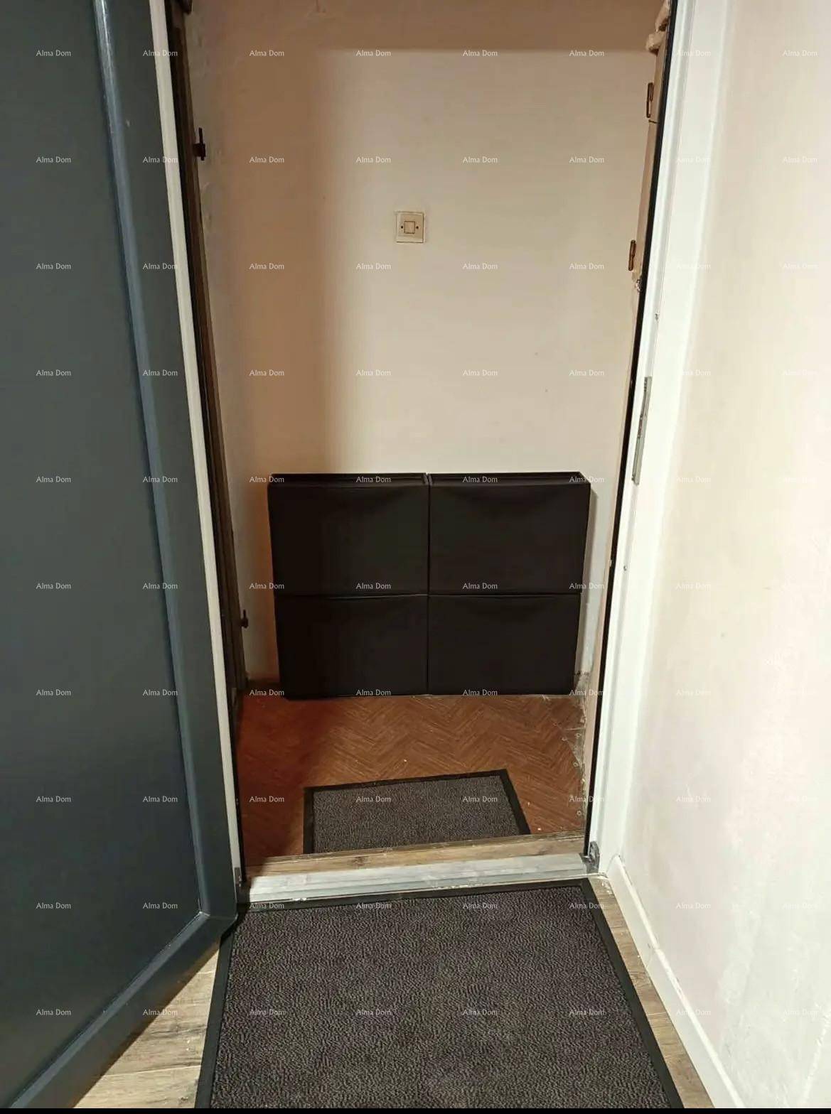 Eingangsbereich mit dunklem Boden und kleiner Ablagefläche.