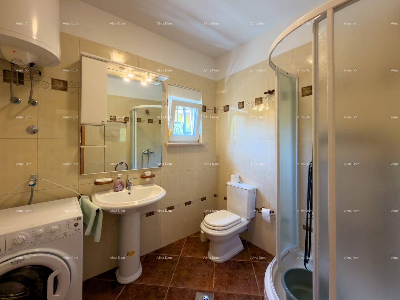 Badezimmer mit Dusche, Waschbecken, Toilette und Waschmaschine.