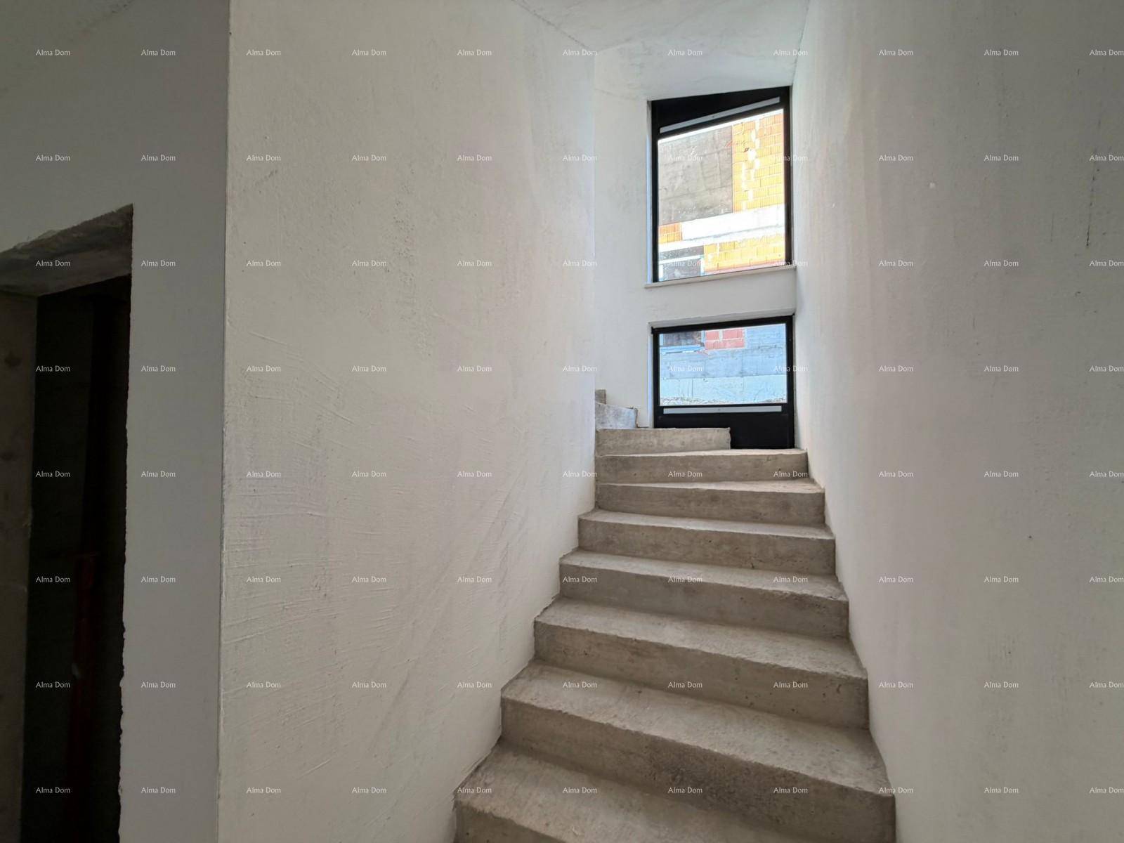 Unfertiges Treppenhaus mit Betonstufen und Fenstern, die Tageslicht hereinlassen.