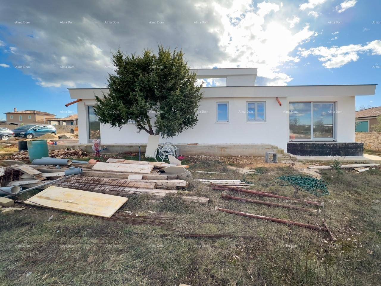 Seitenansicht eines modernen Neubaus mit weißer Fassade und Bauabfällen im Vordergrund auf dem Grundstück.