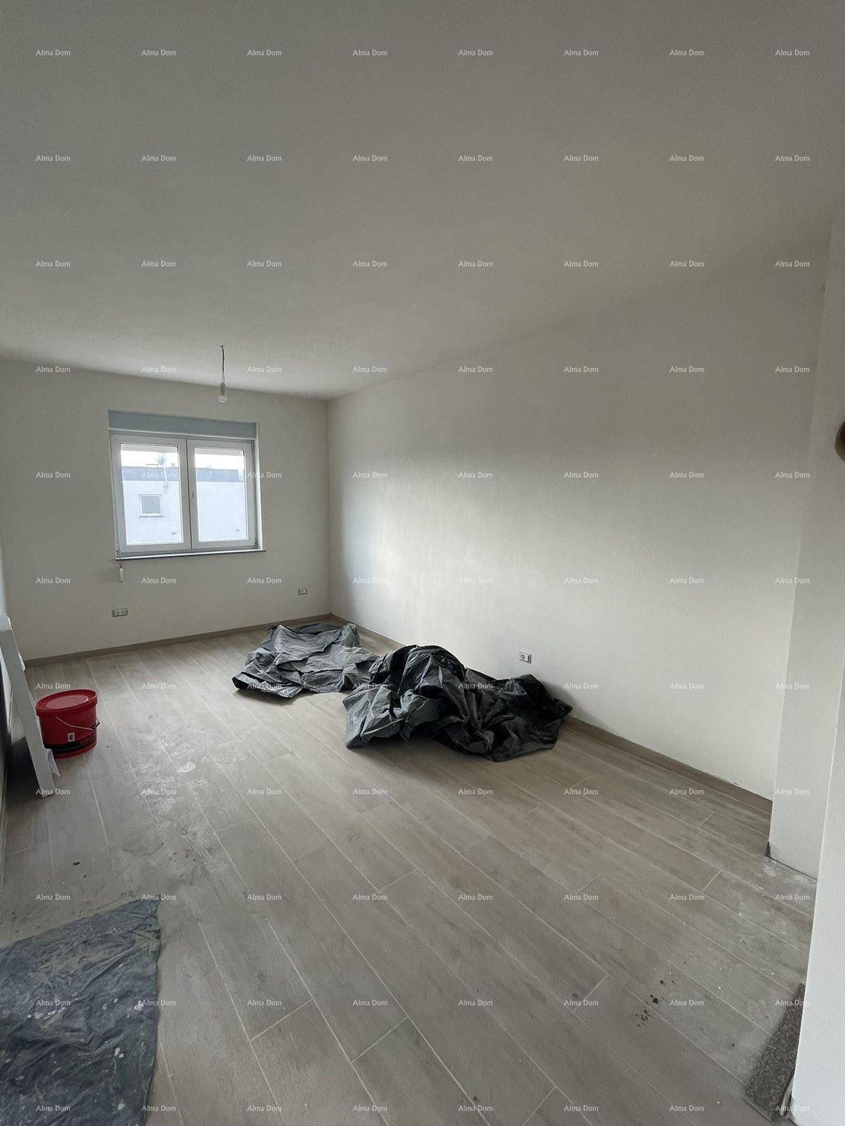 Helles Zimmer im Rohbau mit Fliesenboden, weißen Wänden und gestapelten Baumaterialien.