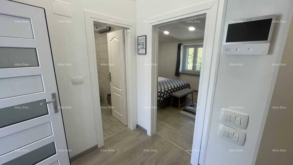 Flur mit Blick in ein Badezimmer und ein weiteres Schlafzimmer, ausgestattet mit Gegensprechanlage.