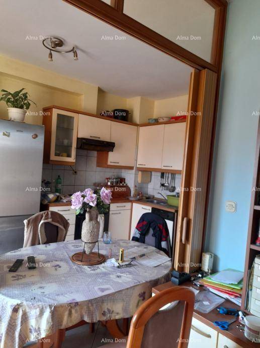 Gemütliche Wohnküche mit Essbereich, weißen Küchenschränken und großem Kühlschrank.