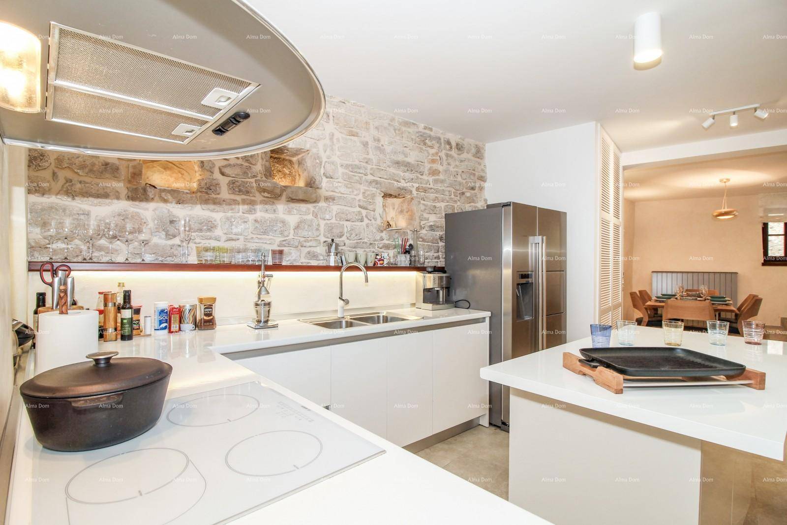 Nahaufnahme der modernen Küche mit Induktionskochfeld, Spüle und Edelstahlkühlschrank.