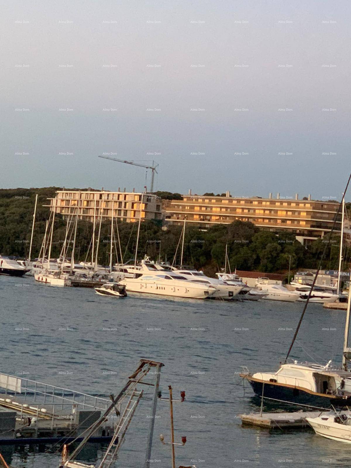 Weitläufige Ansicht eines modernen Gebäudes mit vielen Balkonen und Yachten in der Marina.