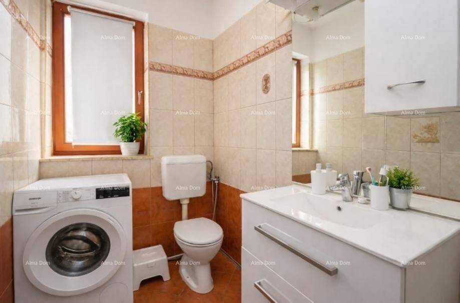 Funktionales Badezimmer mit Waschbecken, Toilette, Waschmaschine und Fenster für Tageslicht.