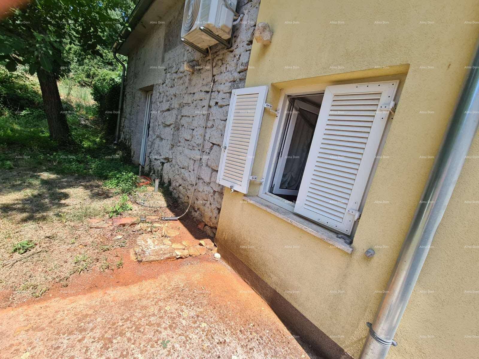Seitenansicht des gelben Hauses mit Fensterläden und einer Klimaanlage an der Wand.