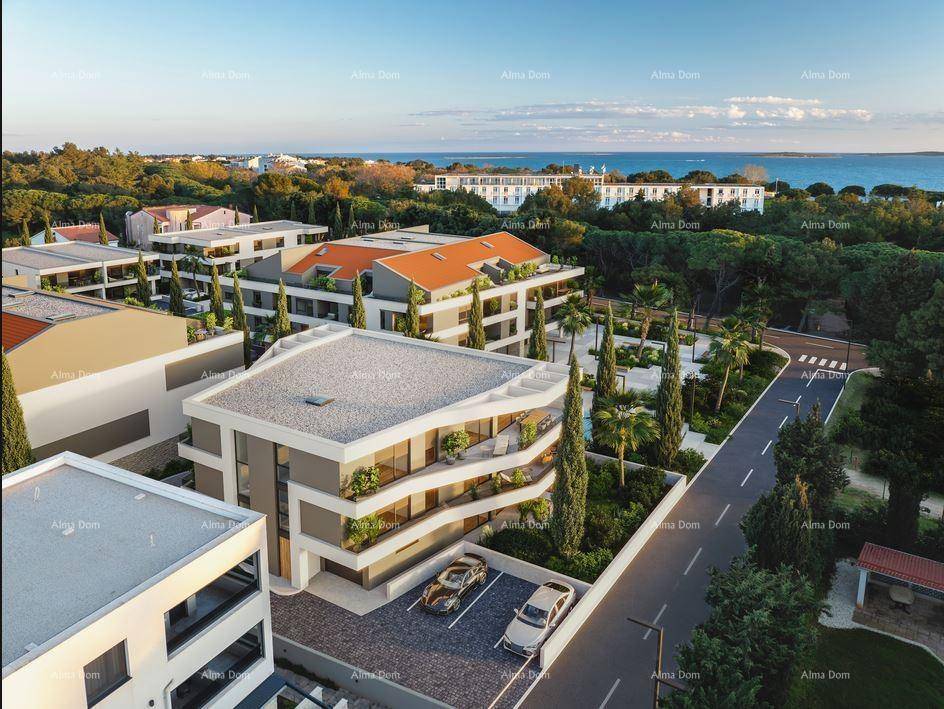Moderne Wohngebäude mit Meerblick und Parkplätzen in einer grünen, mediterranen Umgebung.