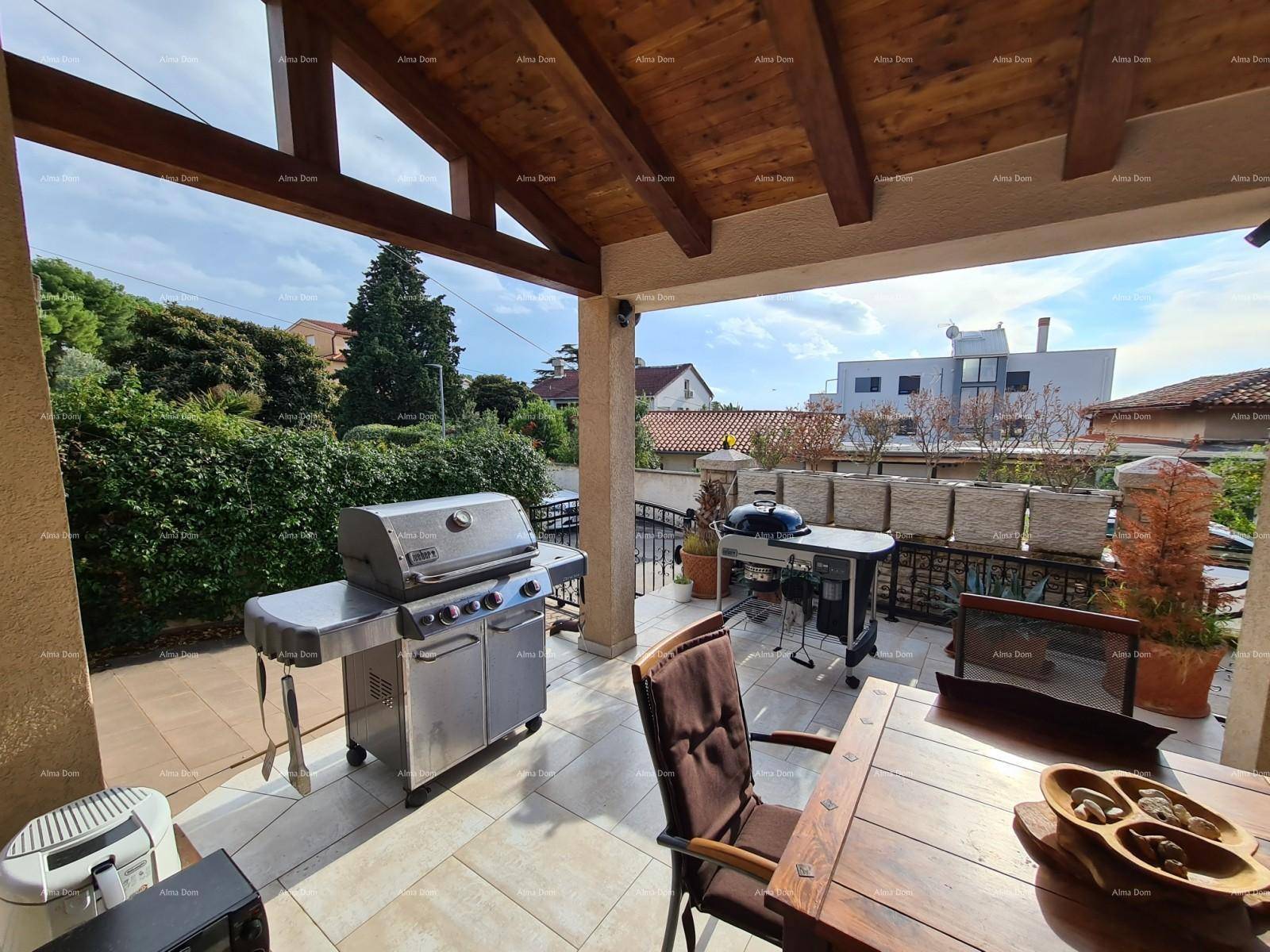 Überdachte Terrasse mit zwei Grills und Sitzgelegenheiten, perfekt für Sommerabende.