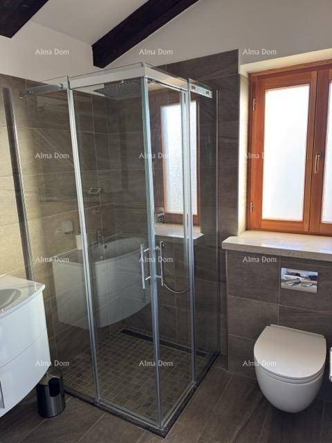Elegantes Badezimmer mit großer Glasdusche, dunklen Fliesen und Fenster für Tageslicht.