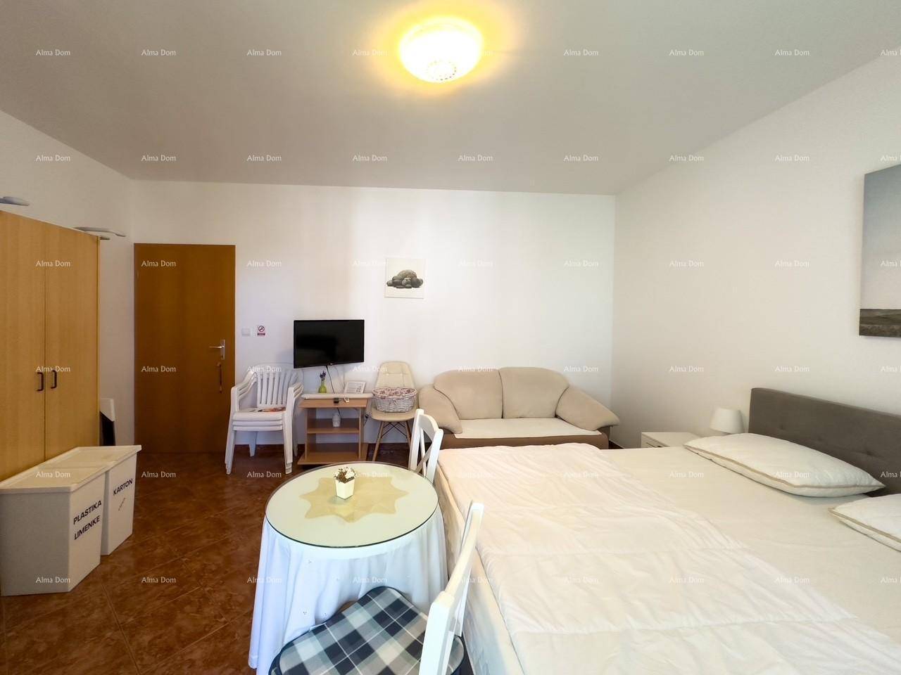 Geräumiges Schlafzimmer mit Doppelbett, Kleiderschrank und kleiner Essecke, ideal für ein Studio-Apartment.