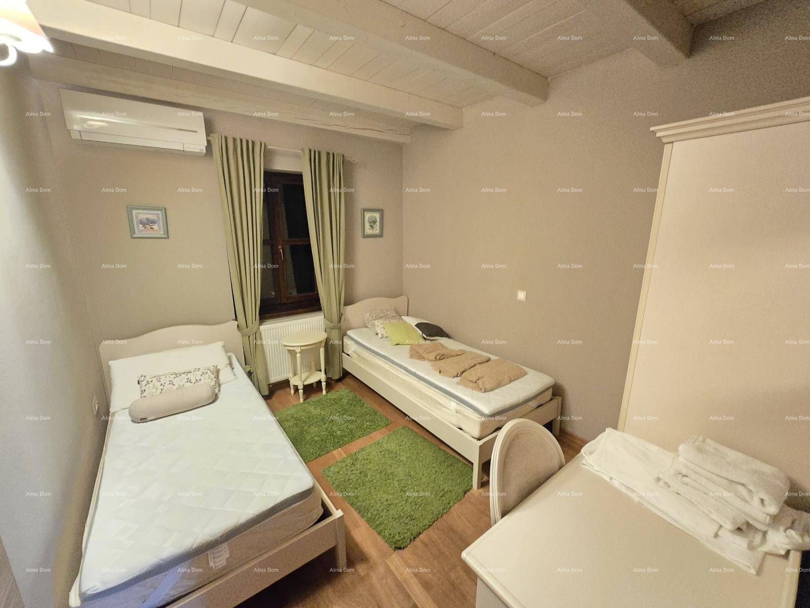 Gemütliches Schlafzimmer mit zwei Einzelbetten, Holzboden, Klimaanlage und sichtbaren Deckenbalken.