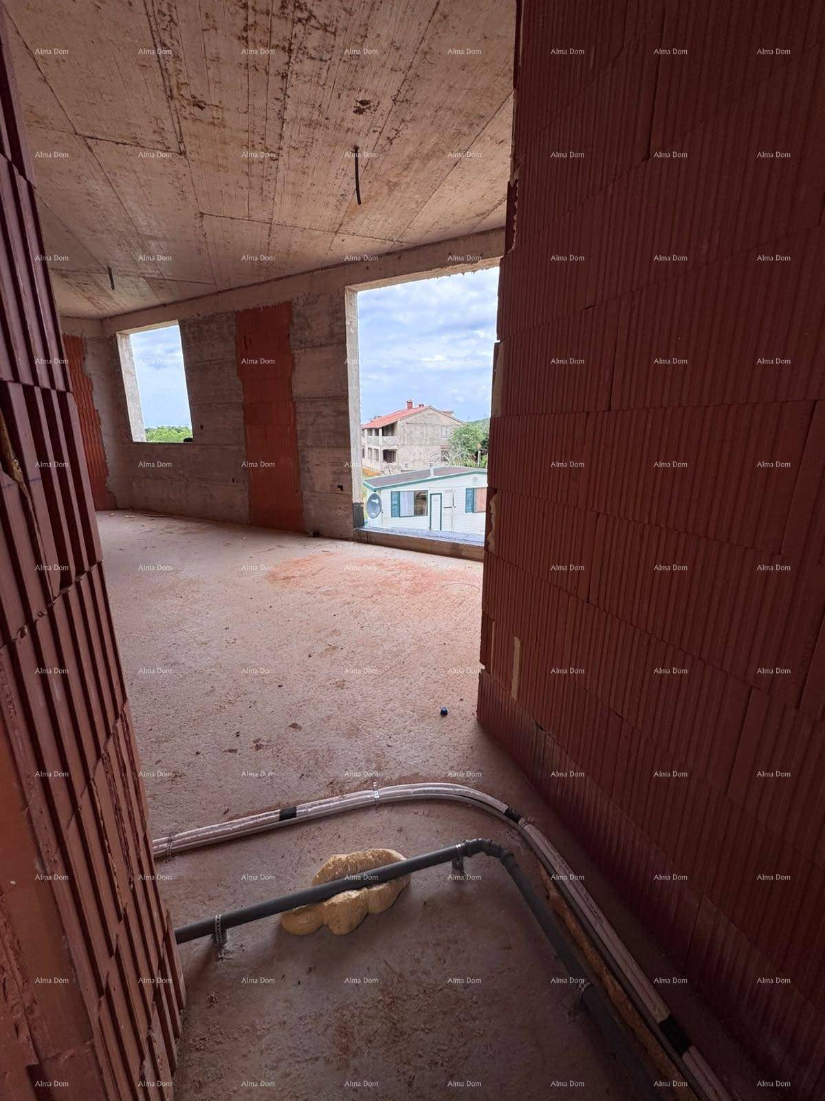 Rohbau mit geschwungener Wand, mehreren Fensteröffnungen und sichtbaren Leitungen am Boden.