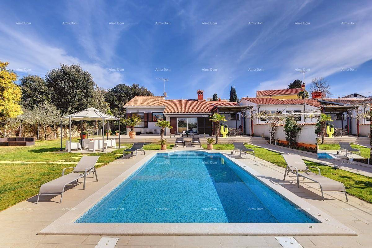 Weitläufiger Garten mit großem Pool, Liegestühlen und Pavillon unter blauem Himmel.