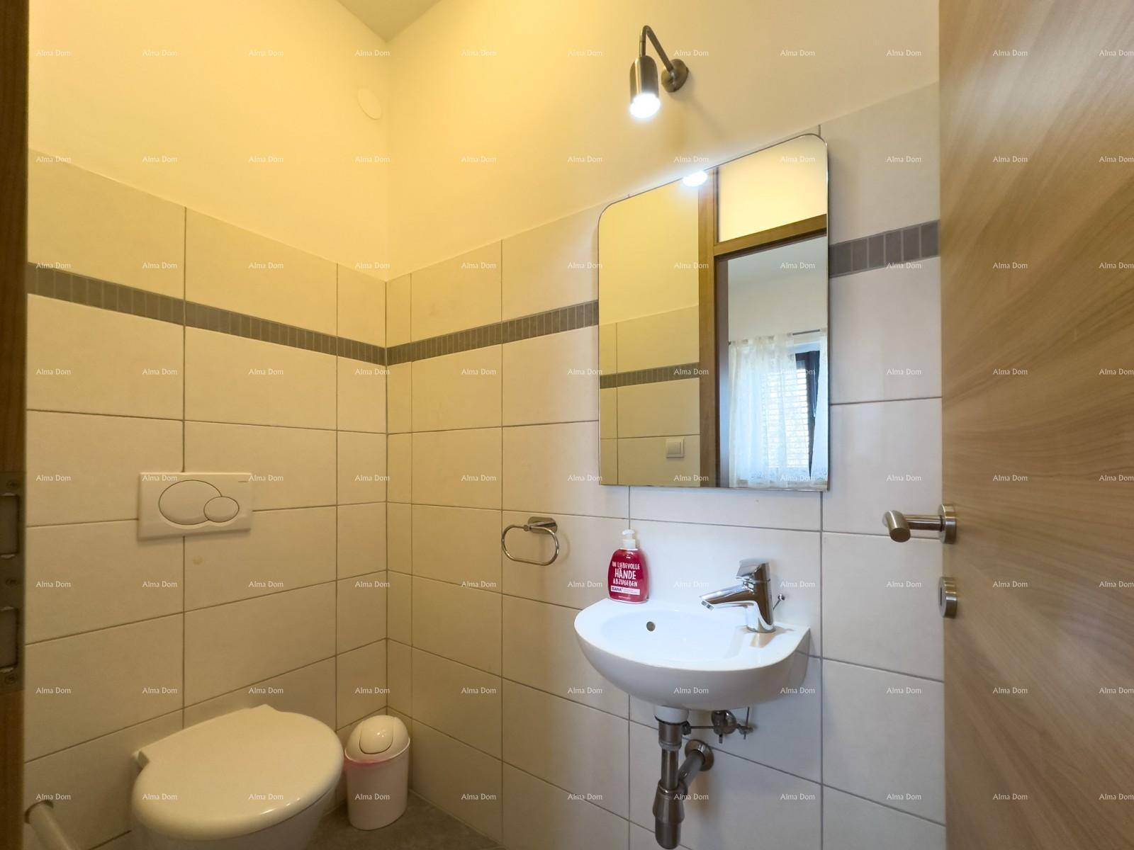 Kleines Gäste-WC mit Wand-WC, Waschbecken und hellen Fliesen an den Wänden.