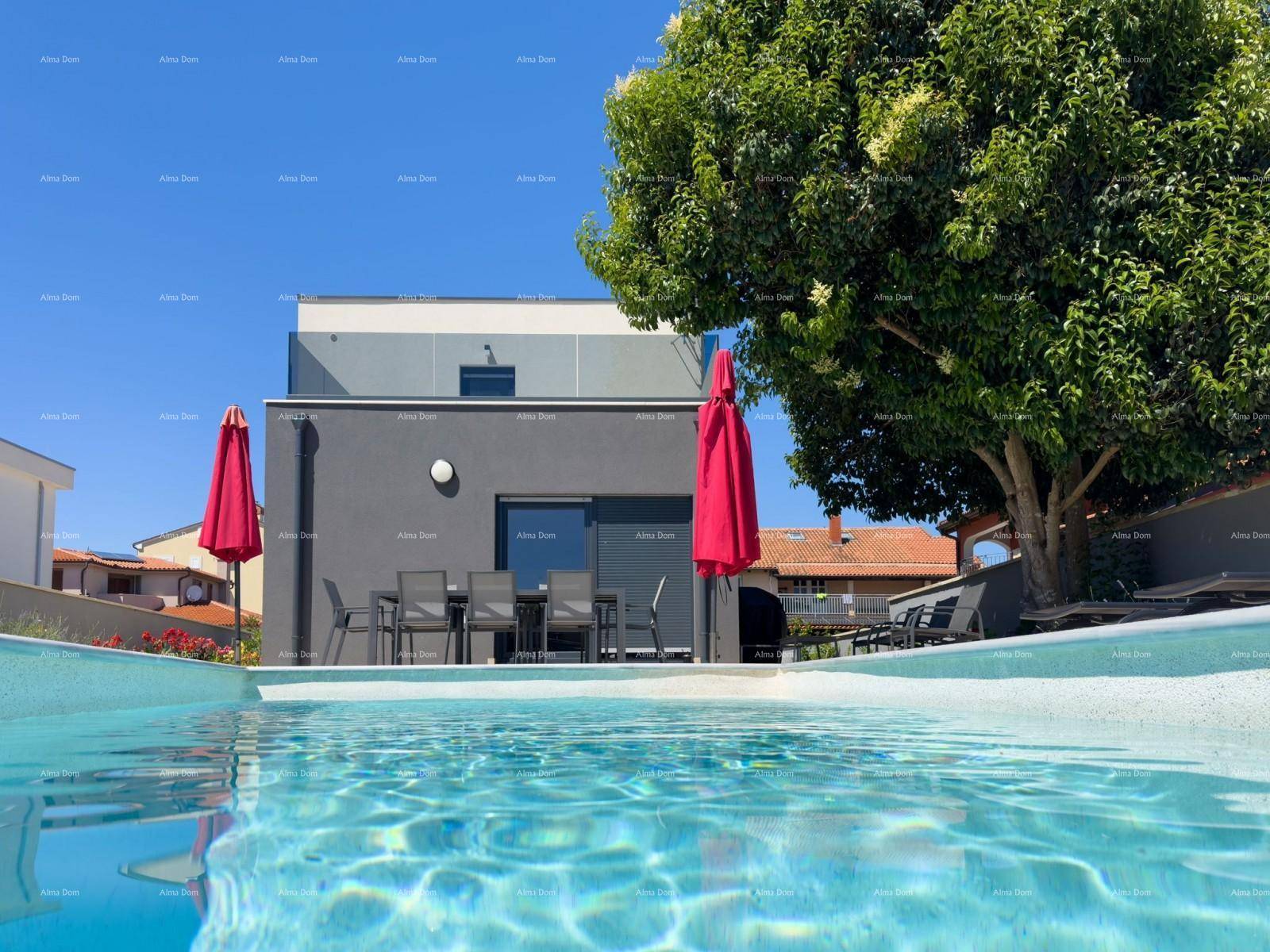 Erfrischender Pool mit Blick auf die moderne Architektur der Villa und die roten Sonnenschirme.
