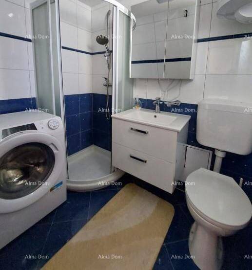 Modernes Badezimmer mit Duschkabine, WC, Waschbecken und Waschmaschine, in Blau-Weiß-Fliesen.