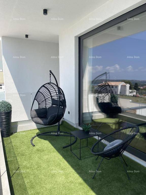 Kleiner Balkon mit Kunstrasen, Hängesessel und Blick auf die Umgebung.