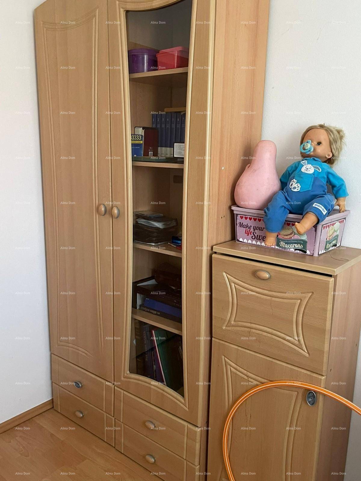 Kinderzimmer oder Gästezimmer mit einem Holzschrank und dekorativen Elementen, hell und funktional.