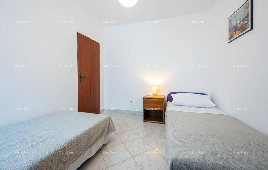 Einfaches Schlafzimmer mit zwei Einzelbetten und Fliesenboden, hell und funktional eingerichtet.