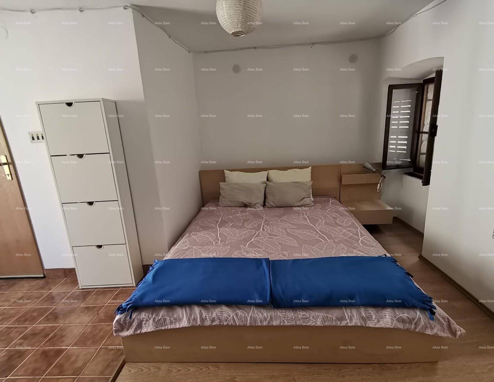 Schlafzimmer mit Doppelbett, Nachttischen und Fenster mit Holzläden.