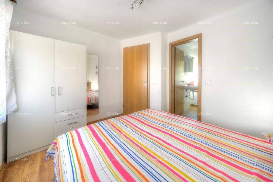 Schlafzimmer mit Doppelbett, Kleiderschrank und Zugang zu einem angrenzenden Badezimmer.