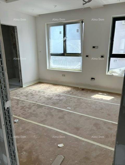 Heller Raum im Bau mit zwei Fenstern und vorbereitetem Boden für die Endverlegung.