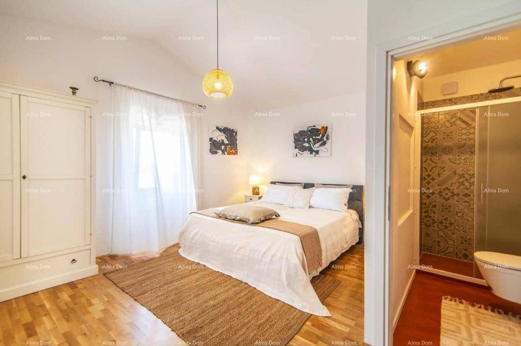 Geräumiges Schlafzimmer mit Doppelbett, weißem Kleiderschrank und direktem Zugang zum Badezimmer.