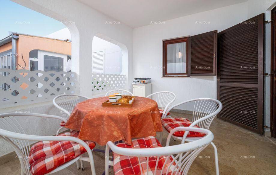 Gemütliche Terrasse mit Esstisch, Stühlen und Frühstückstablett, umgeben von weißen Mauern.