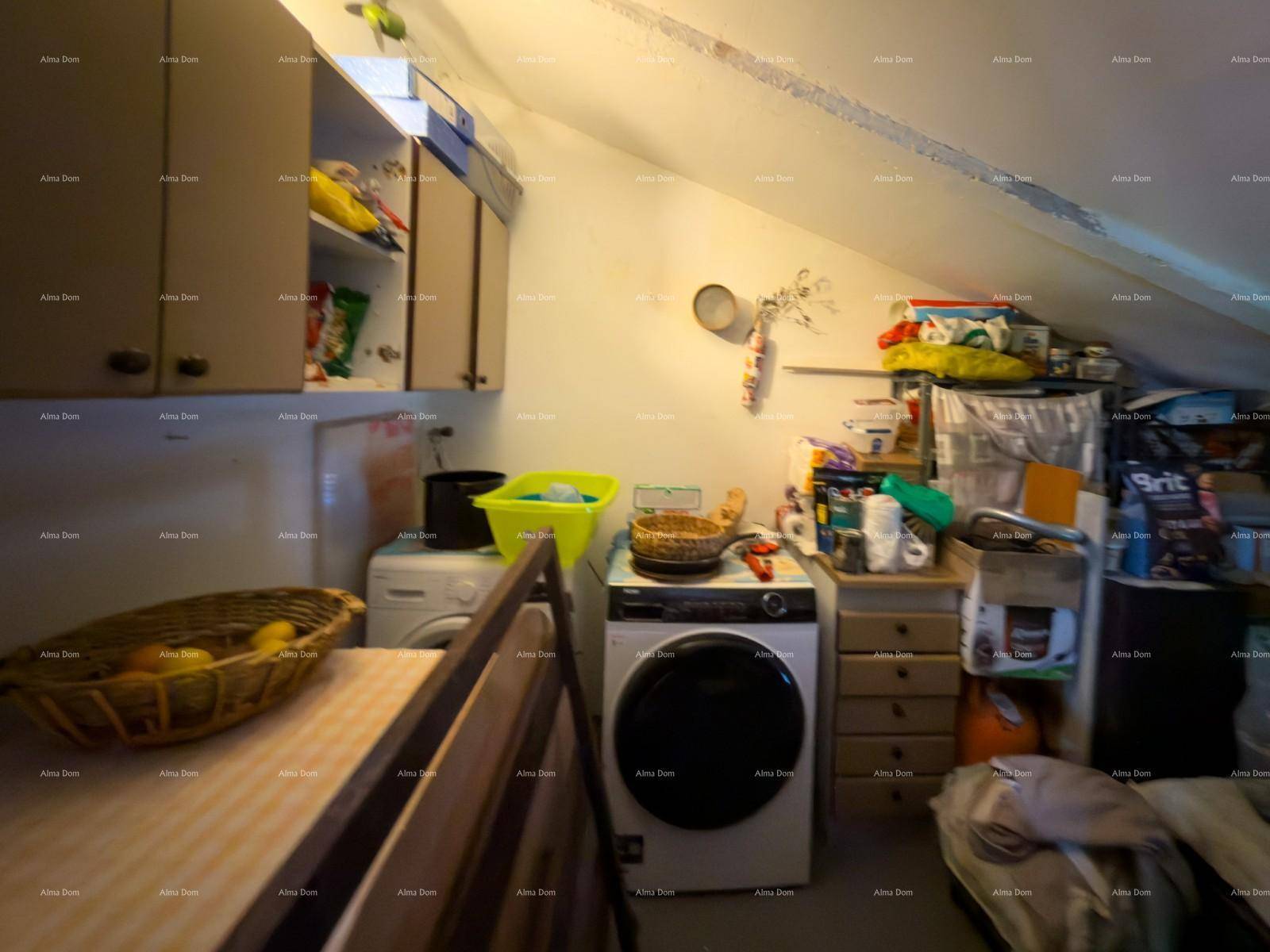 Hauswirtschaftsraum im Dachgeschoss mit Waschmaschine und Trockner, unter einer schrägen Decke.