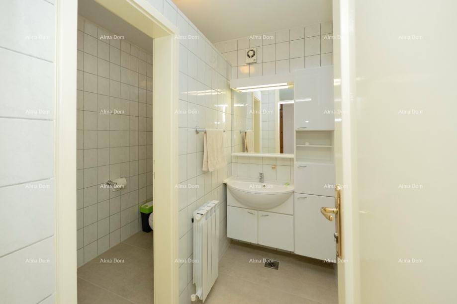 Funktionales Badezimmer mit Waschbecken, Spiegelschrank und separatem WC-Bereich.