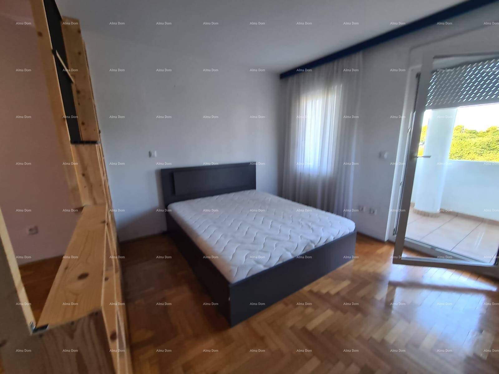 Schlafzimmer mit Doppelbett, Holzboden und Balkonzugang.