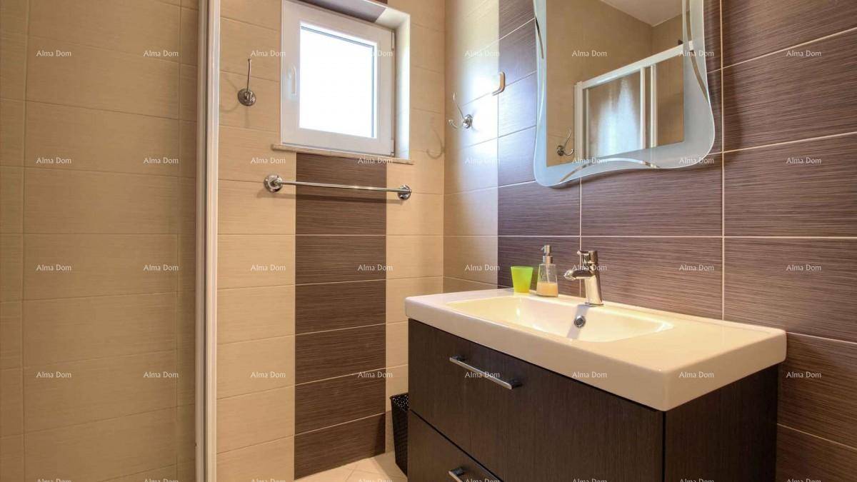 Modernes Badezimmer mit Duschkabine, Waschbecken und zweifarbigen Fliesen.