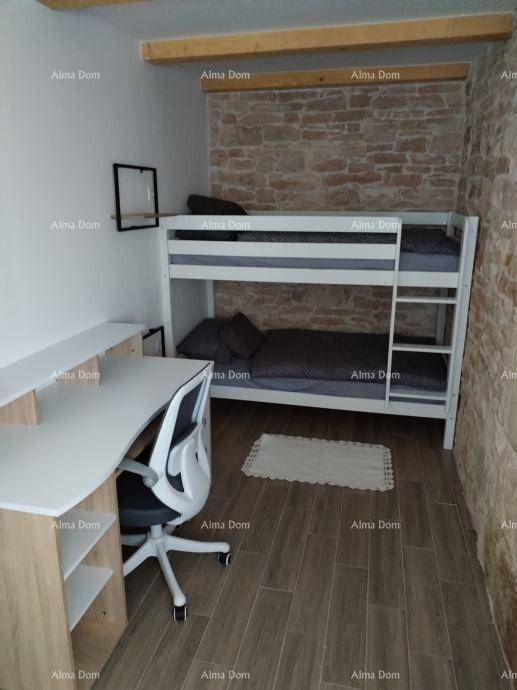 Kinderzimmer mit Etagenbett, Schreibtisch und Steinwand, bietet einen funktionalen und gemütlichen Schlaf- und Arbeitsbereich.