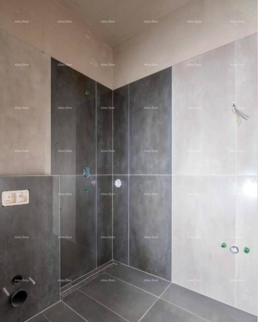 Badezimmer im Rohbau mit modernen grauen und weißen Fliesen an Wänden und Boden.