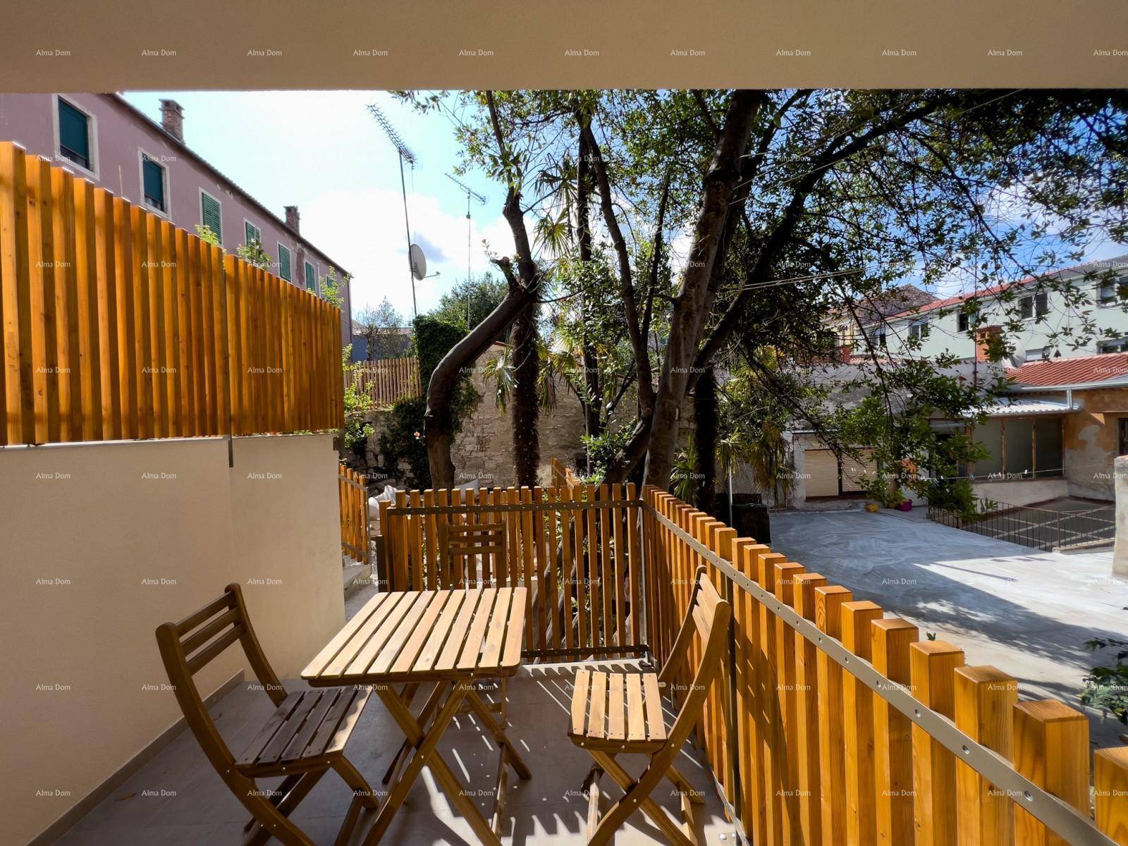 Sonniger Balkon mit Holzzaun und kleinem Holztisch, umgeben von Bäumen und viel Grün.
