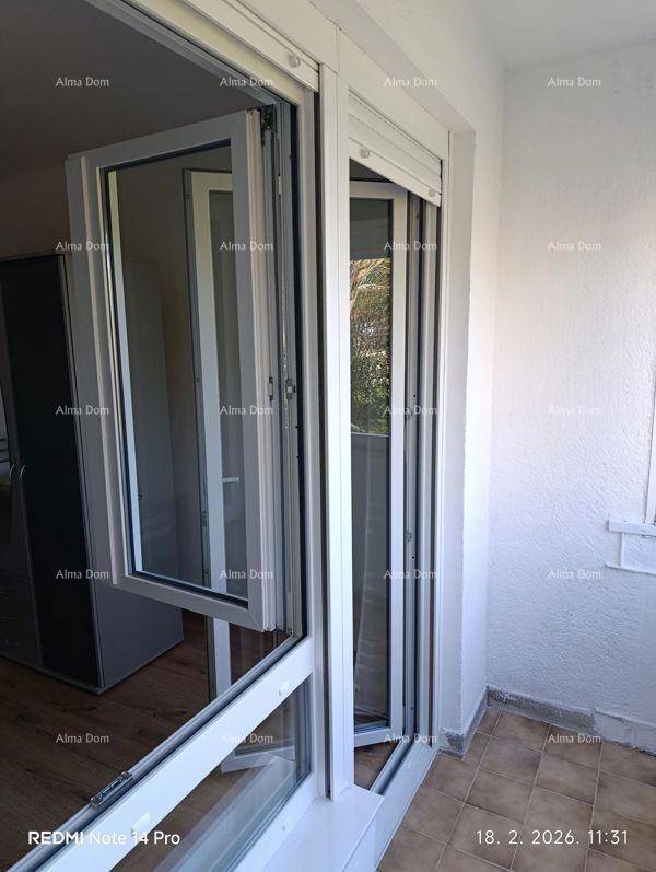 Heller Balkon mit Fliesenboden und geöffneten Fenstern, die frische Luft hereinlassen.