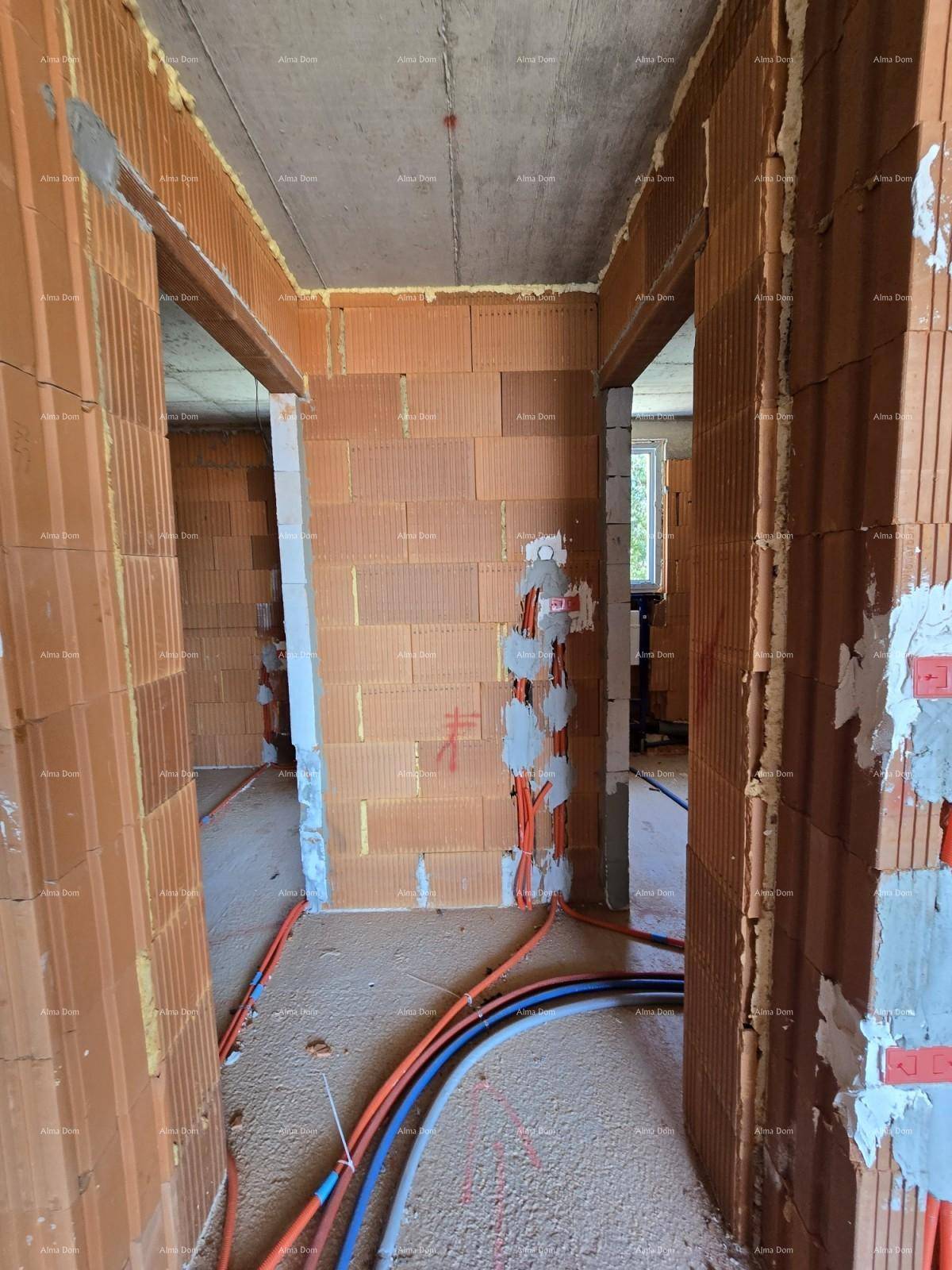 Flurbereich im Rohbau mit unverputzten Ziegelwänden, Betonboden und sichtbaren Leitungen für zukünftige Installationen.