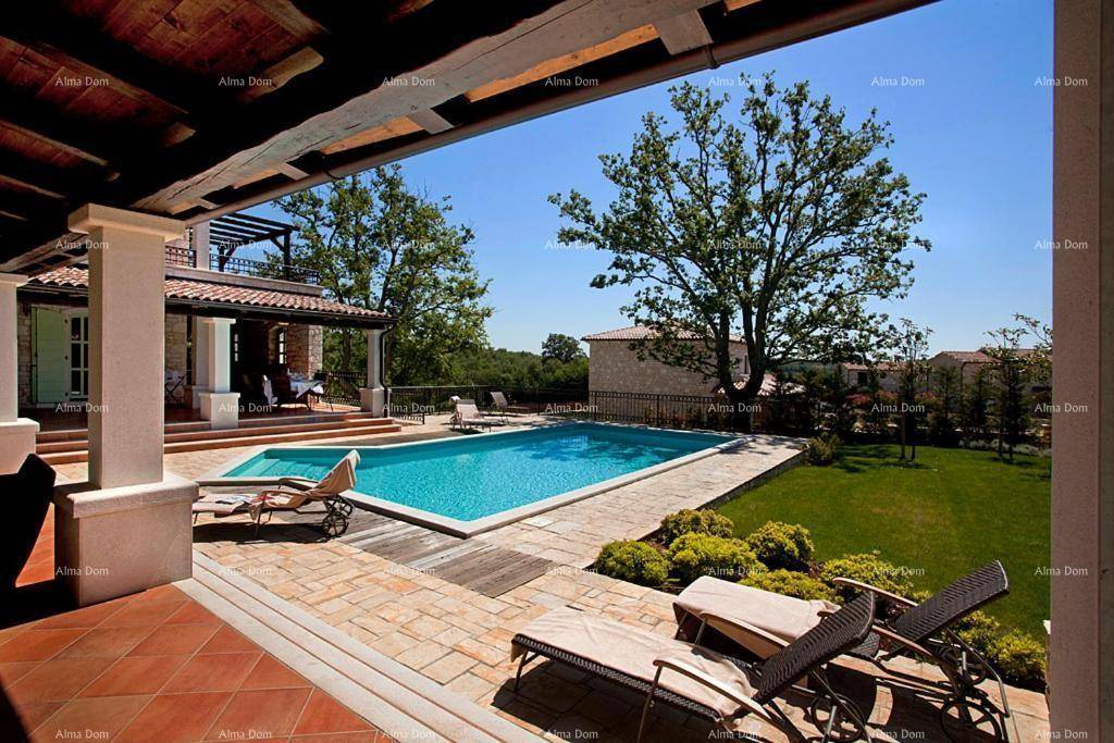 Weitläufige Terrasse mit Sonnenliegen und Blick auf den Pool sowie die umliegende Landschaft.
