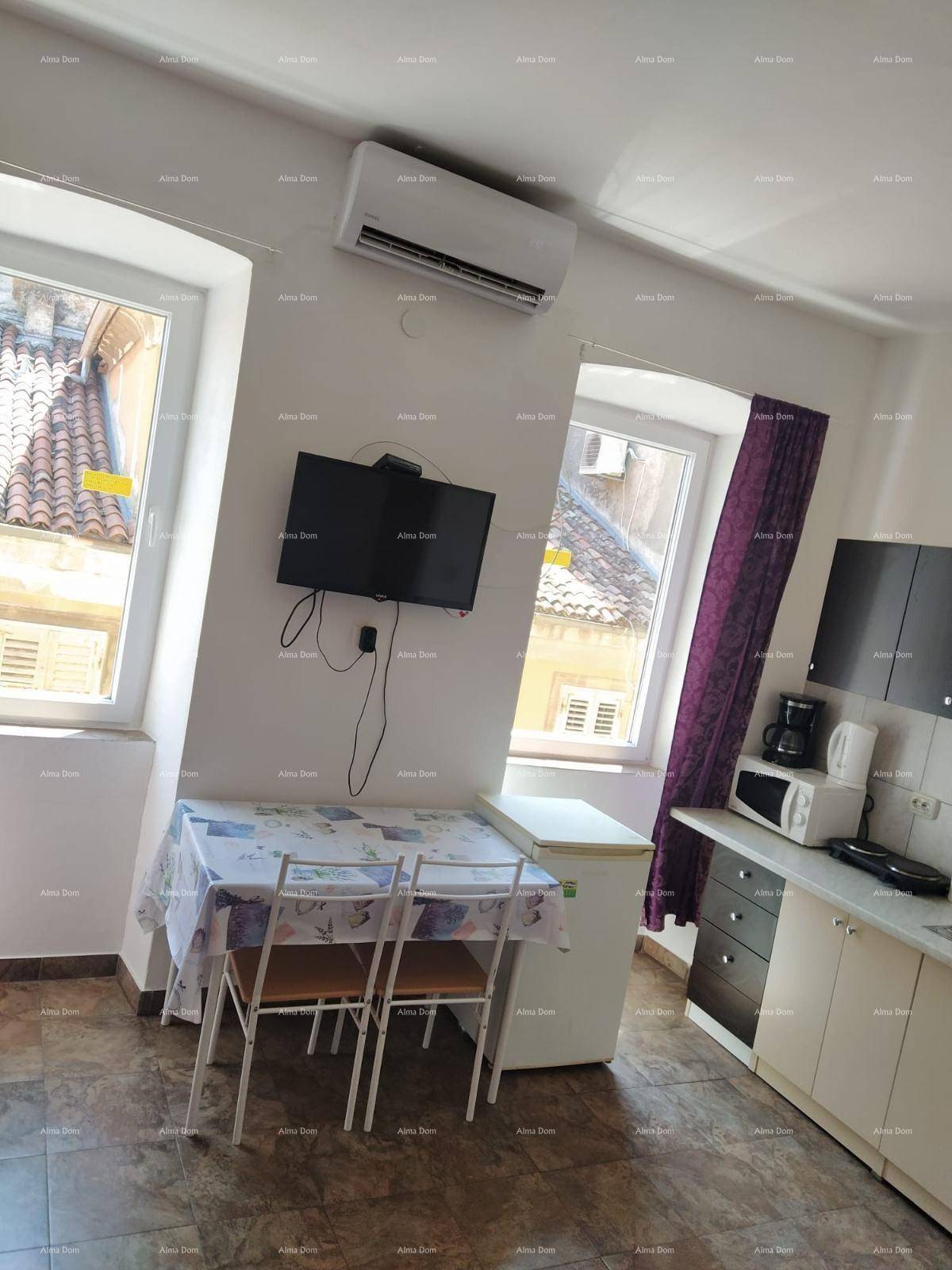 Essbereich und Küchenzeile in einem Studio-Apartment mit Blick auf die umliegenden Dächer.