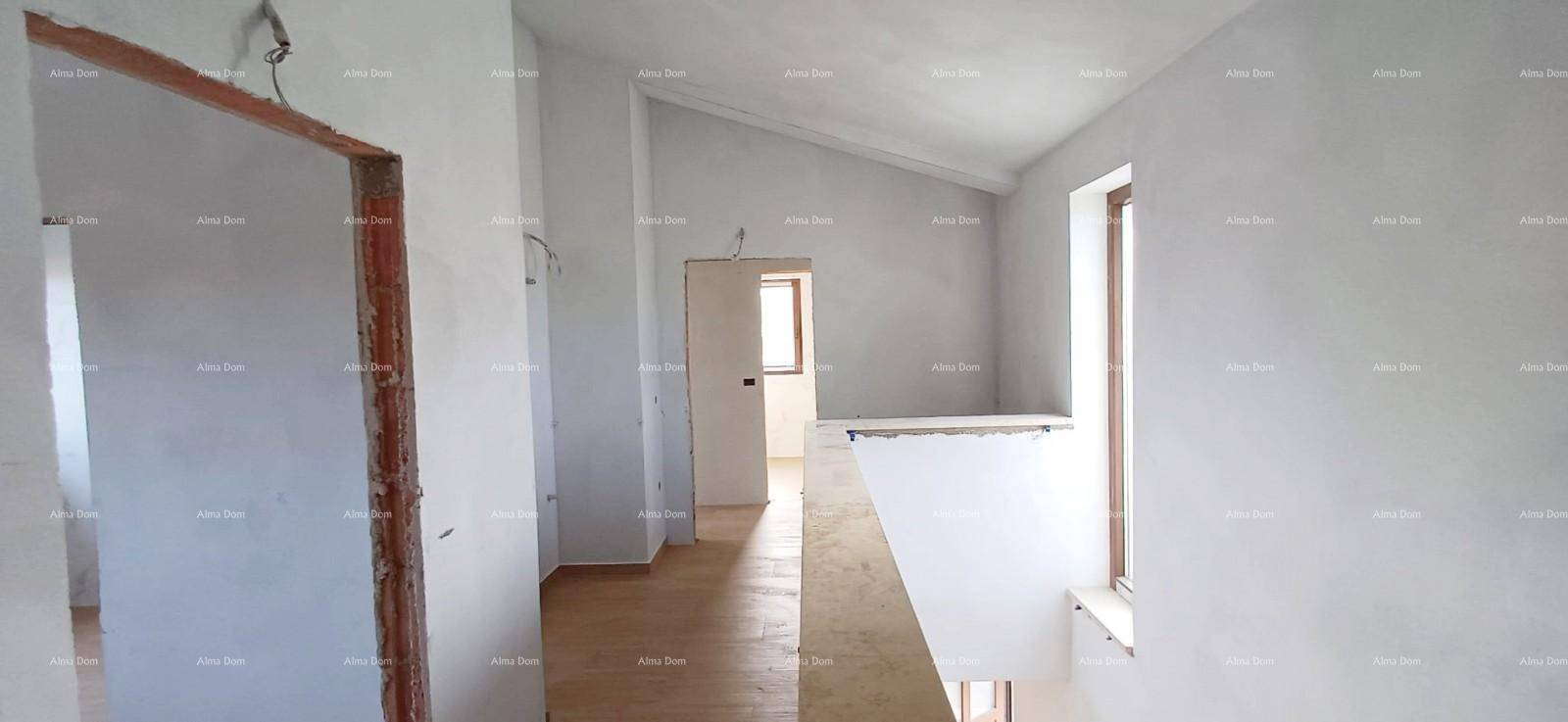 Treppenaufgang und Flurbereich im Obergeschoss mit schrägen Decken und Holzboden.