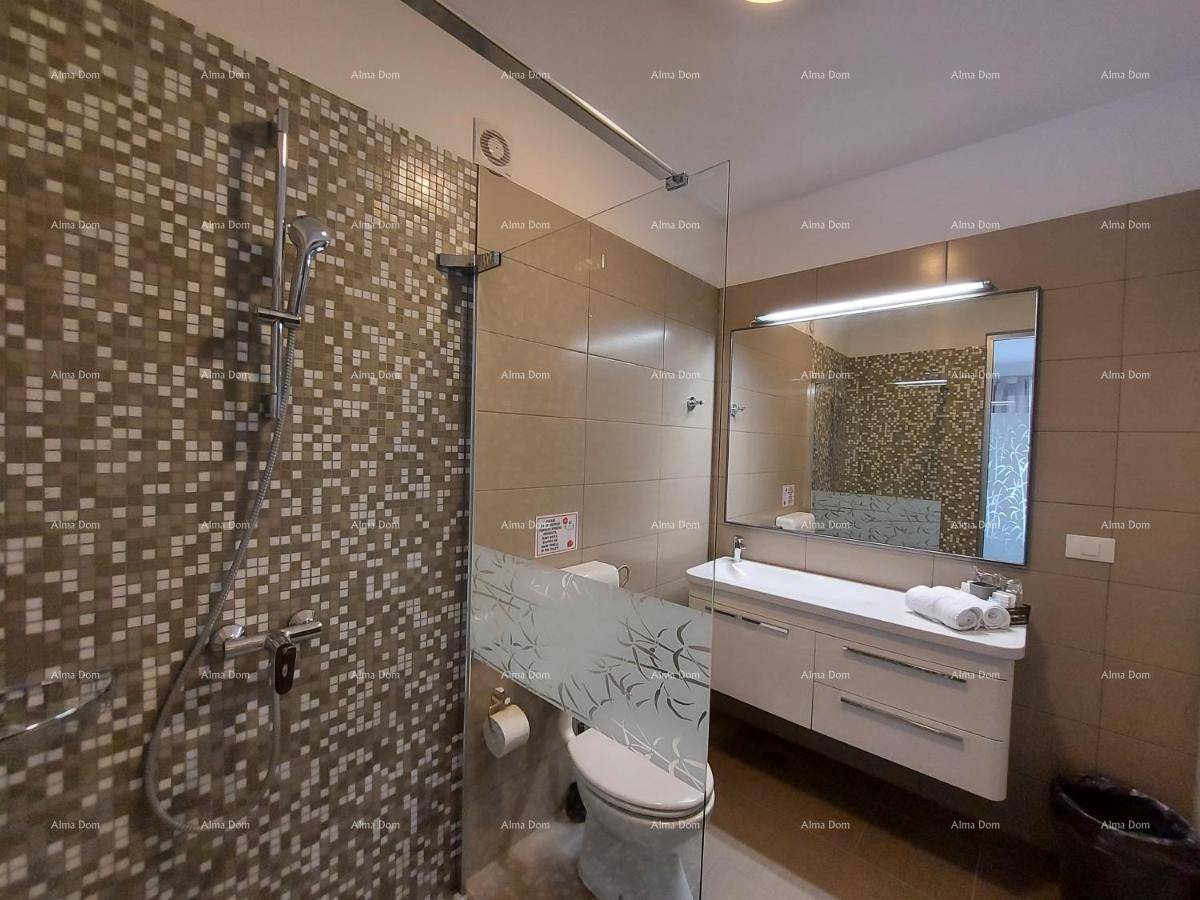 Modernes Badezimmer mit Duschbereich, Waschtisch und Toilette, hell gefliest und gut beleuchtet.