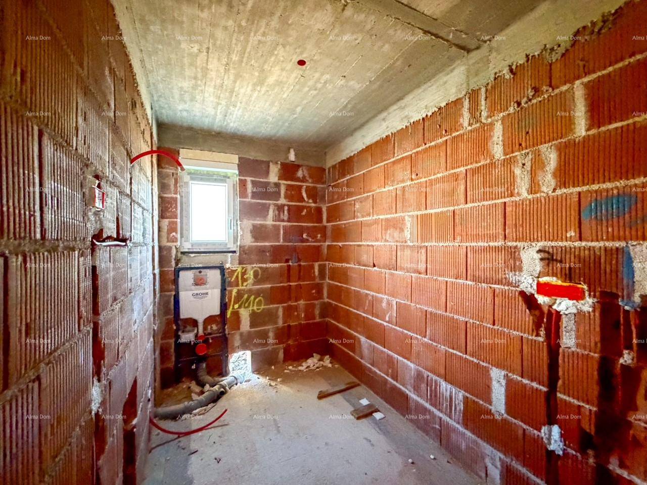 Badezimmer im Rohbau mit Ziegelwänden und vorbereiteter Installation für ein Wand-WC.