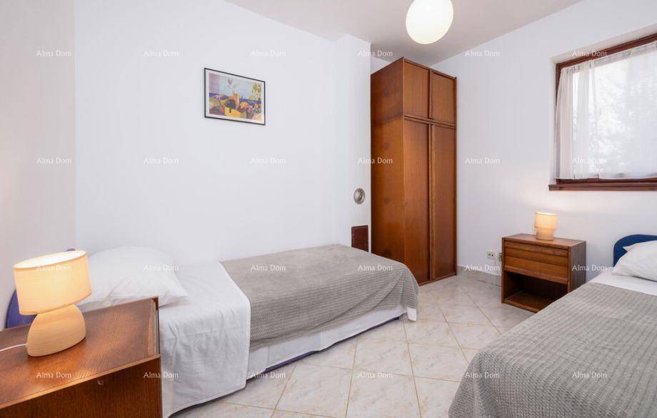 Schlafzimmer mit zwei Einzelbetten, Holzschrank und Nachttischen mit Lampen für eine gemütliche Atmosphäre.