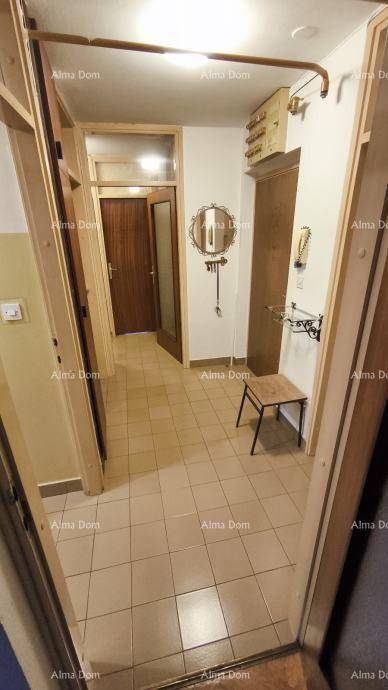Eingangsbereich mit Fliesenboden, Spiegel und Garderobe.