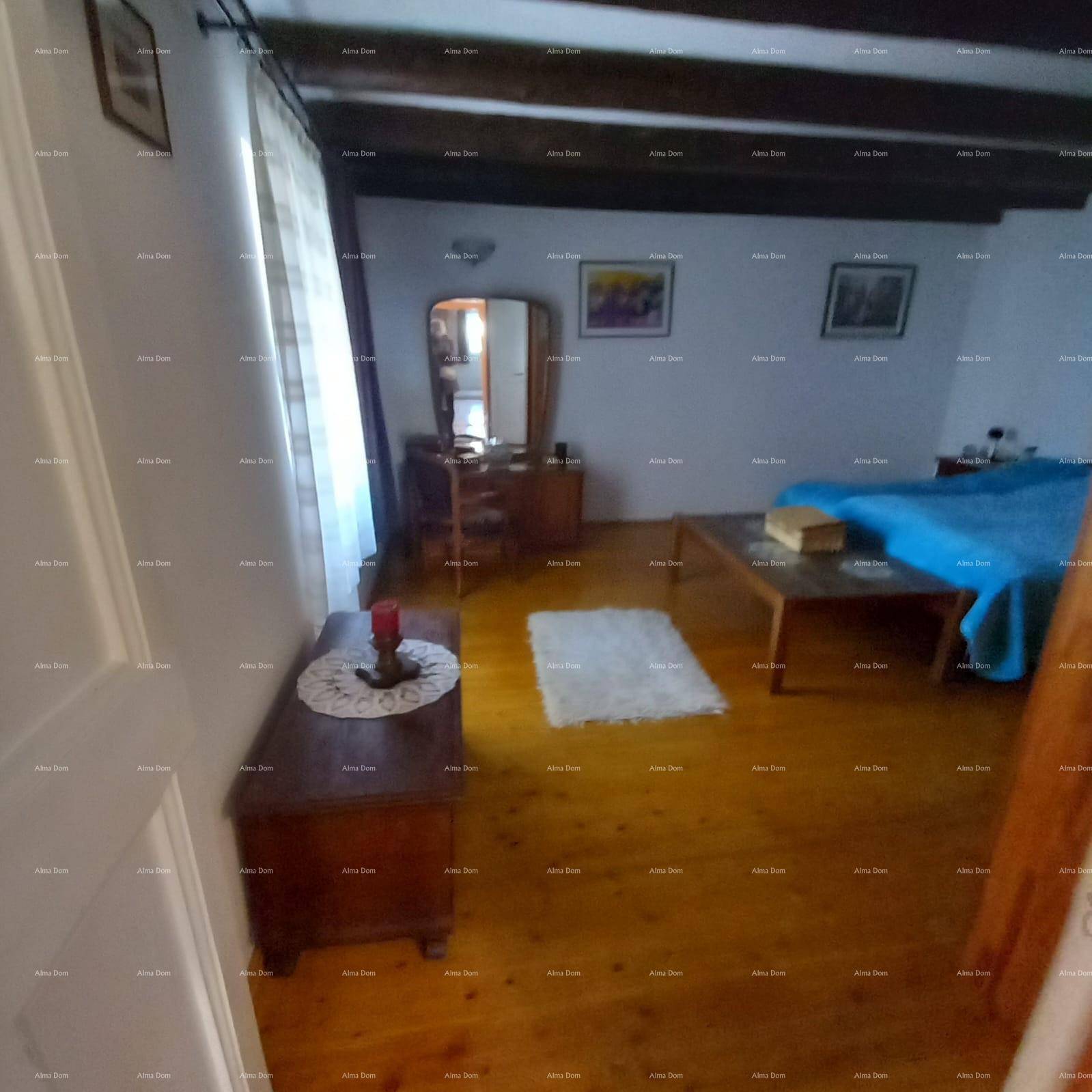 Gemütliches Schlafzimmer mit Holzboden, Doppelbett und traditionellen Möbeln, hell durch ein Fenster.