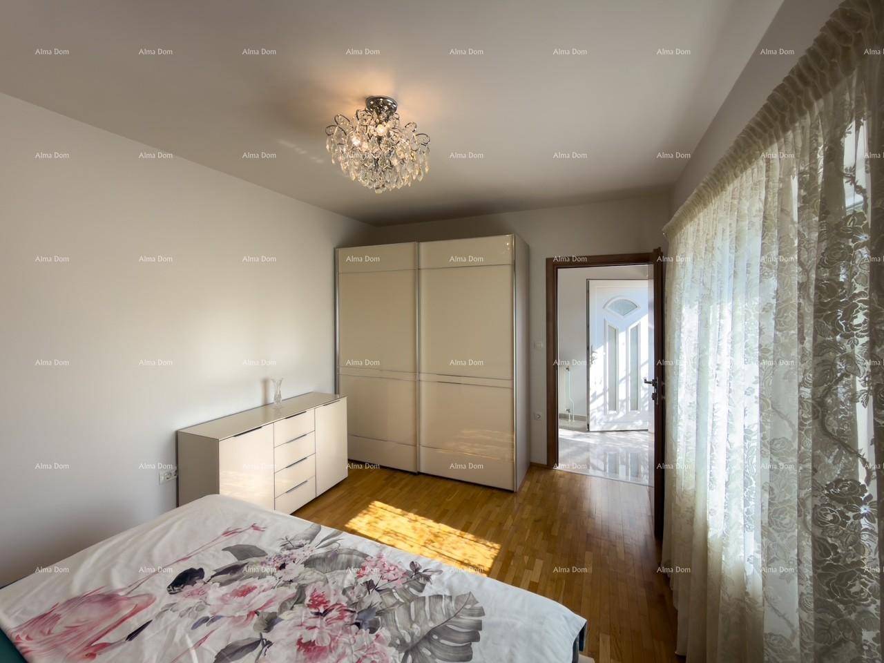 Schlafzimmer mit Holzboden, großem Kleiderschrank und Zugang zum Flur mit Eingangstür.