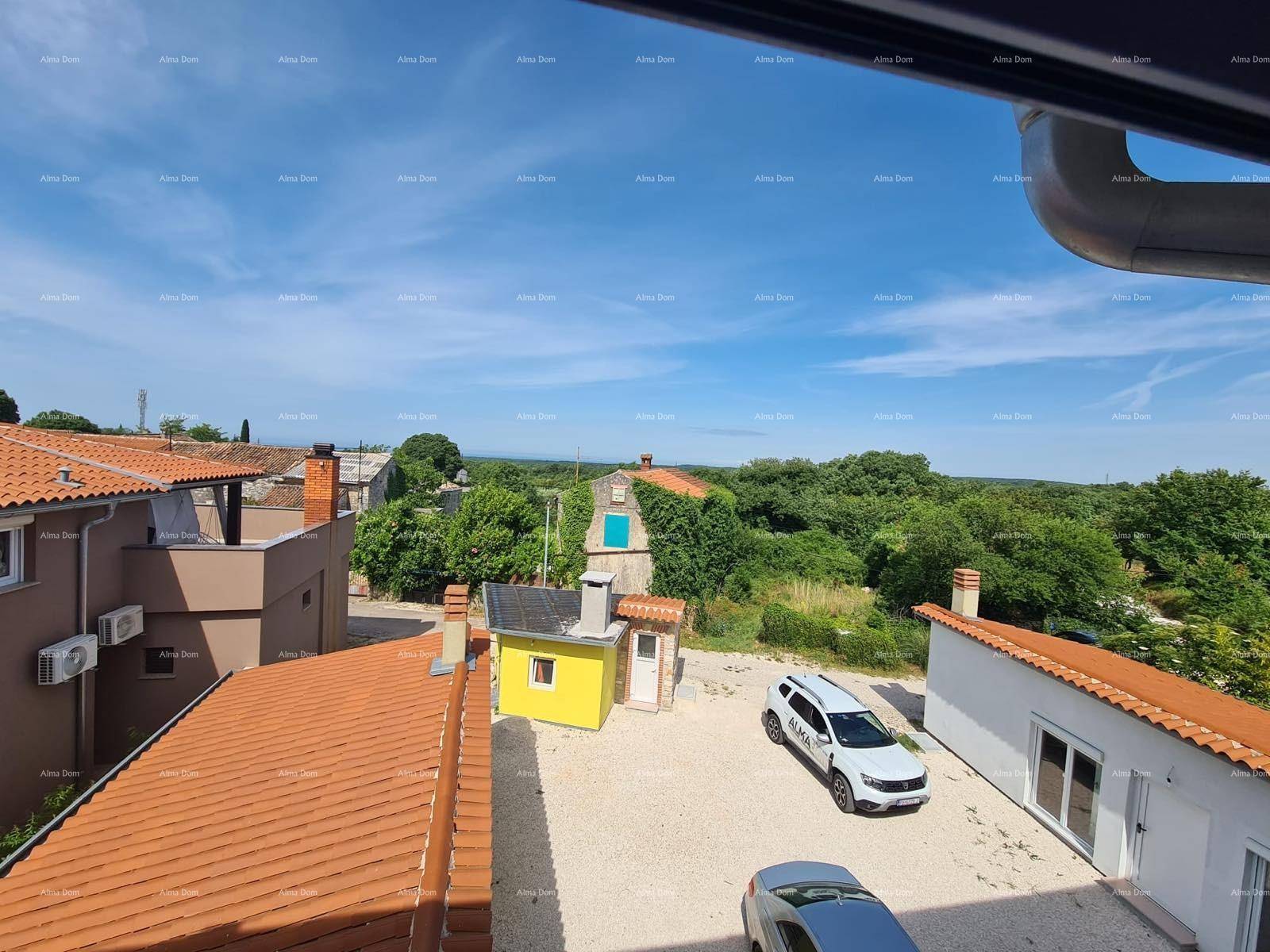 Weitläufige Ansicht des Anwesens mit umliegenden Gebäuden und viel Grün unter blauem Himmel.