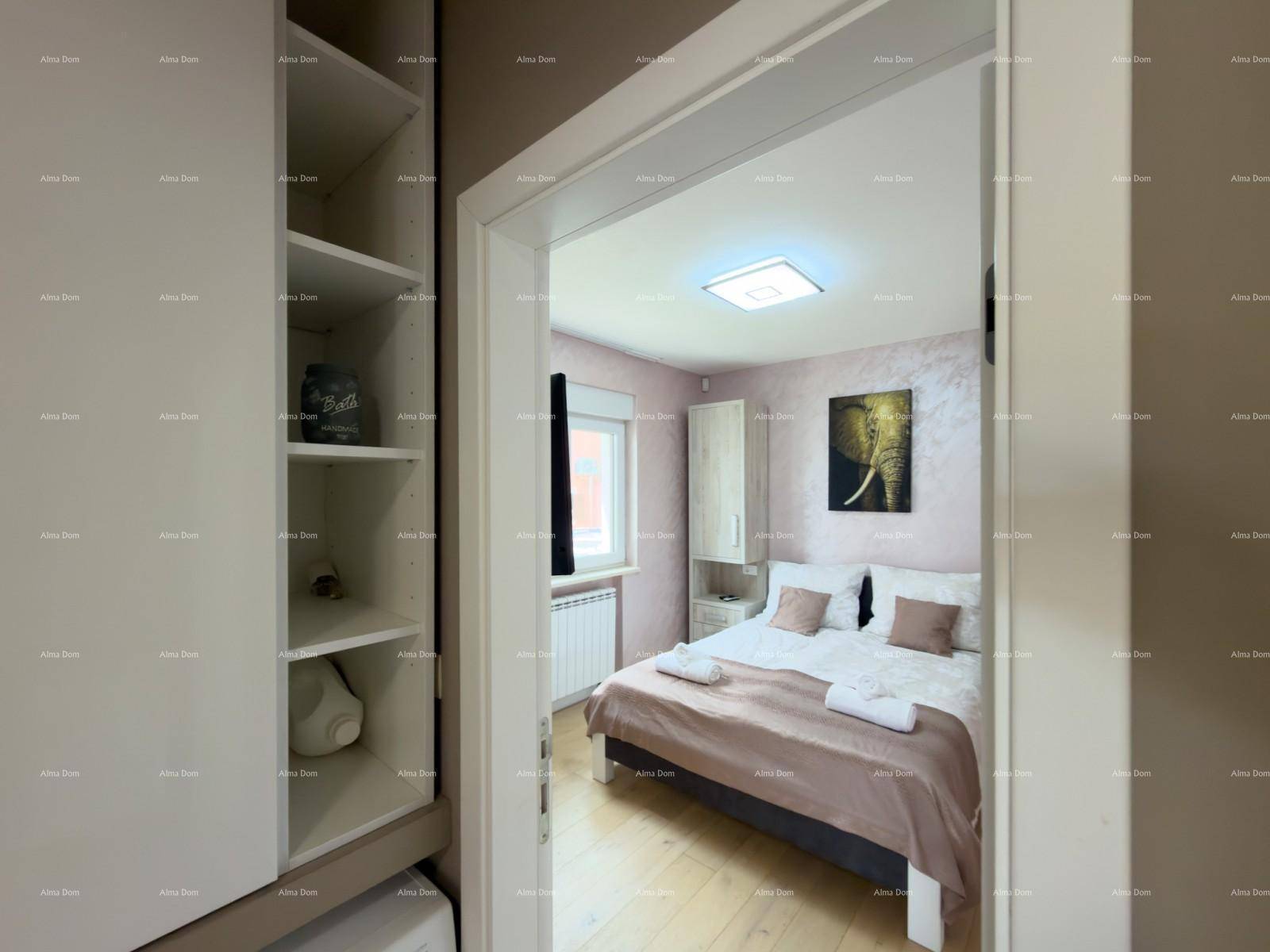 Schlafzimmer mit Doppelbett und Fenster, gesehen vom angrenzenden Stauraum.